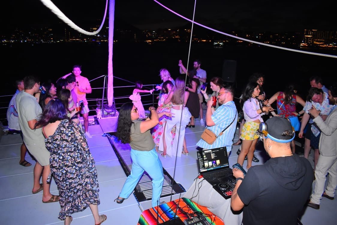 A group of people are dancing on a boat at night.