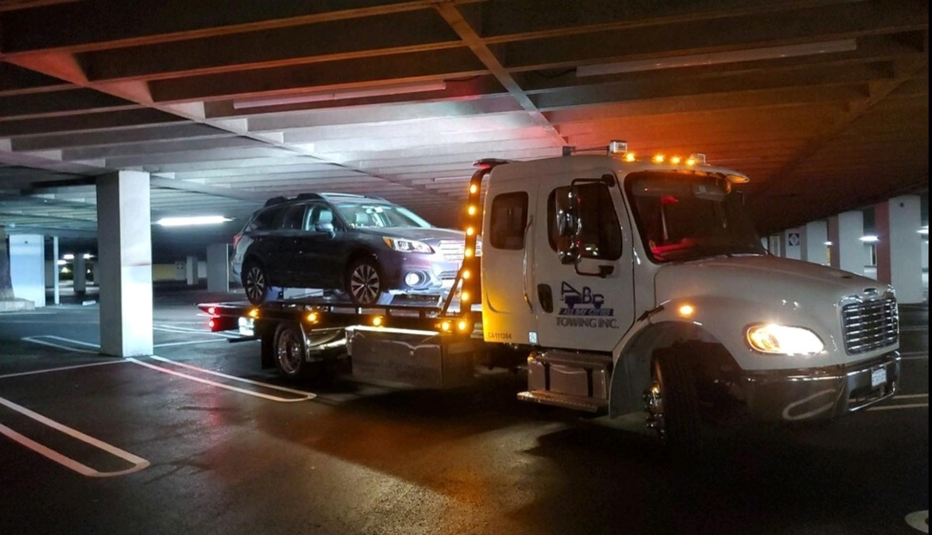 Truck Carrying a Black Car Inside the Parking Lot — Concord, CA — ABC Towing