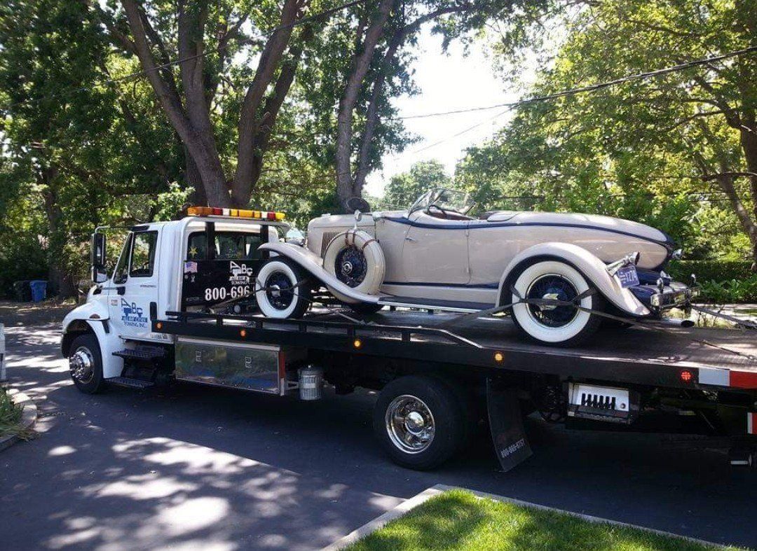 Truck Carrying a White Old Fashioned Car — Concord, CA — ABC Towing