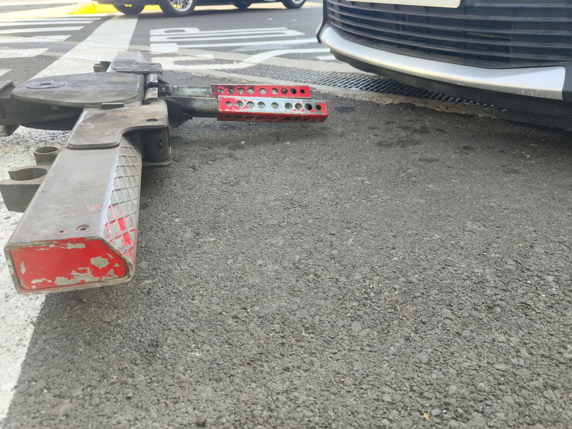 Low view of a tow truck locking mechanism and front of a vehicle. Low view of a tow truck locking mechanism and front of a vehicle.