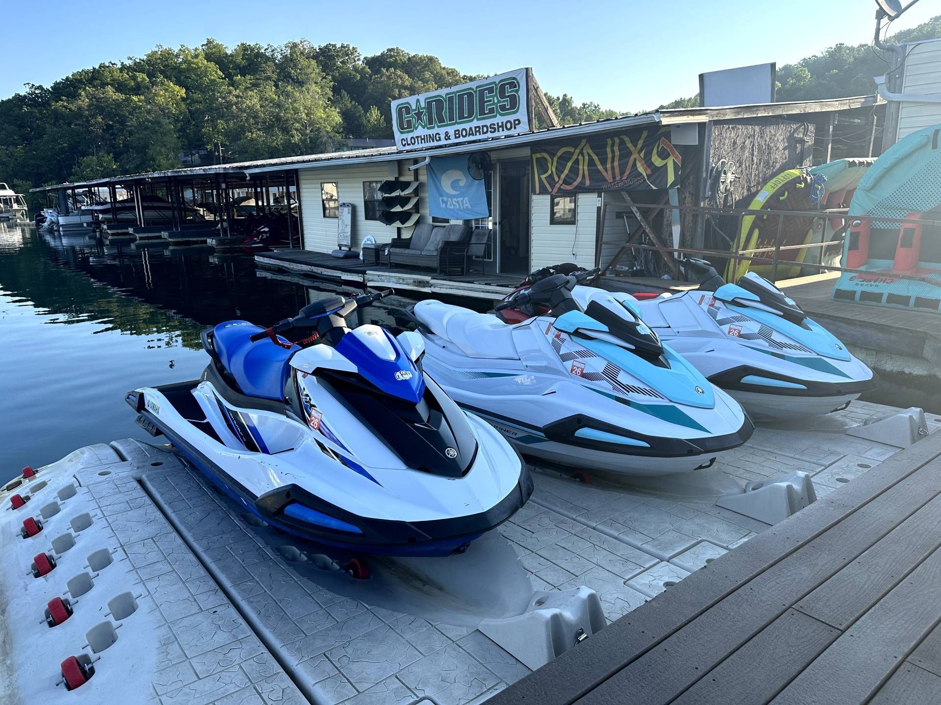 Three jet skis are parked on a dock