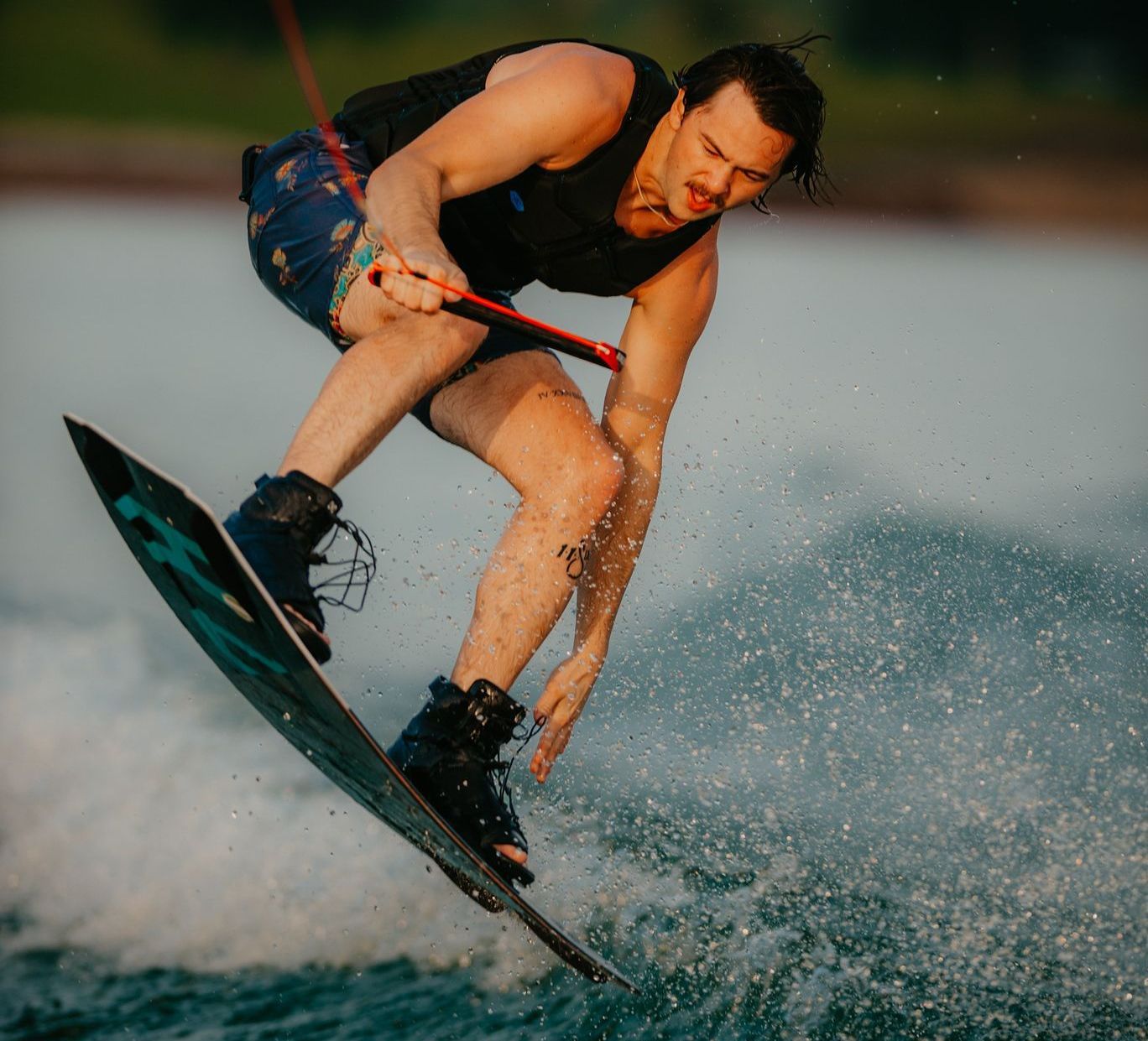 A man on a wakeboard jumping on the water. 