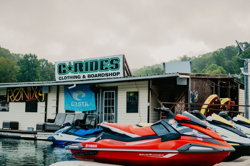 A Jet Ski building with red and blue jet skies in the water out front. 