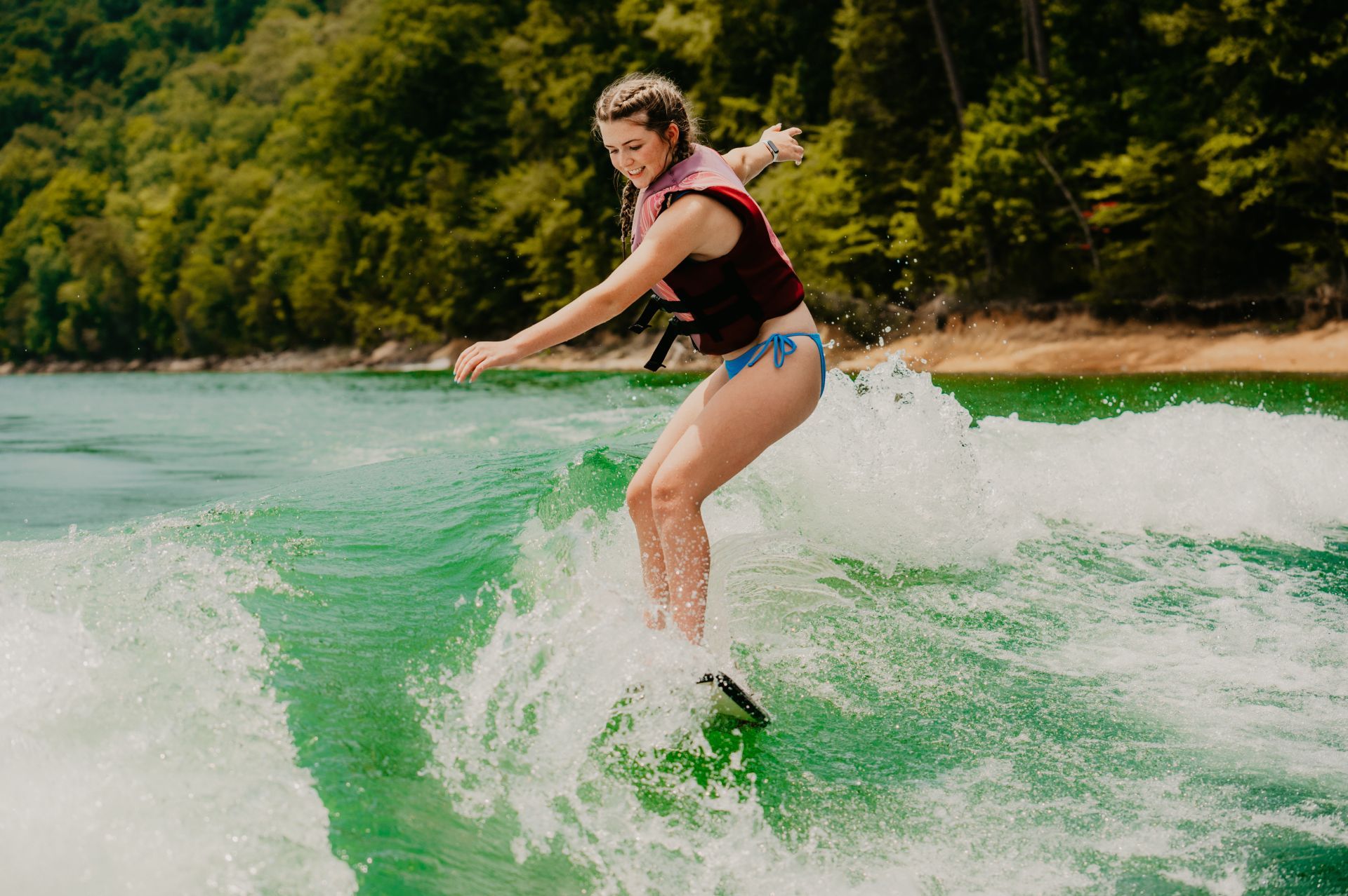 A woman in a bikini is water skiing on a lake