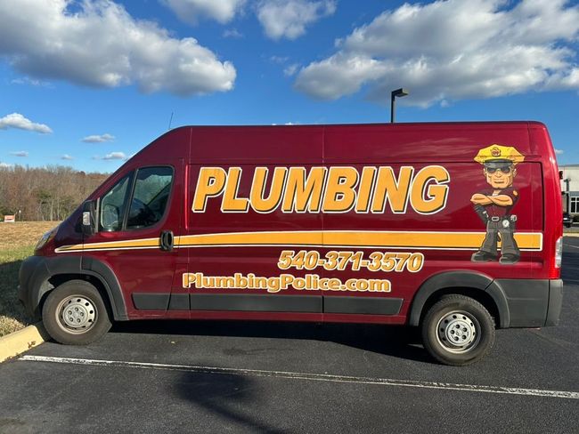 A plumbing police van is parked on the side of the road