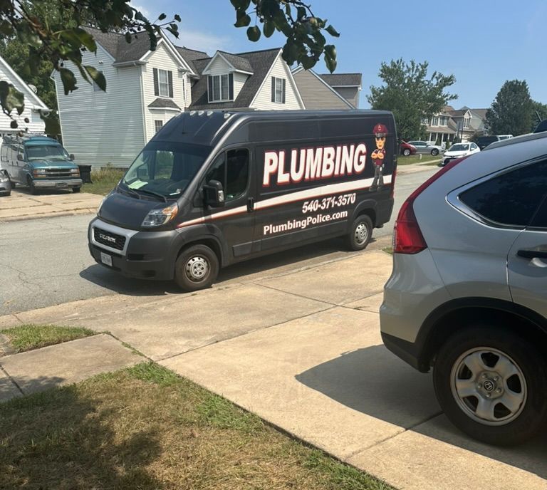 A plumbing police van is parked on the side of the road