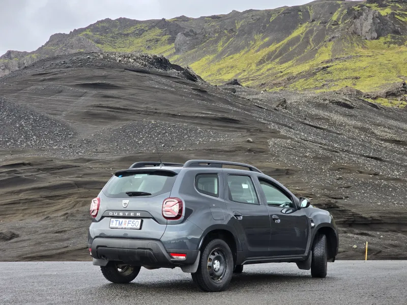 A silver suzuki vitara with black wheels on a white background.