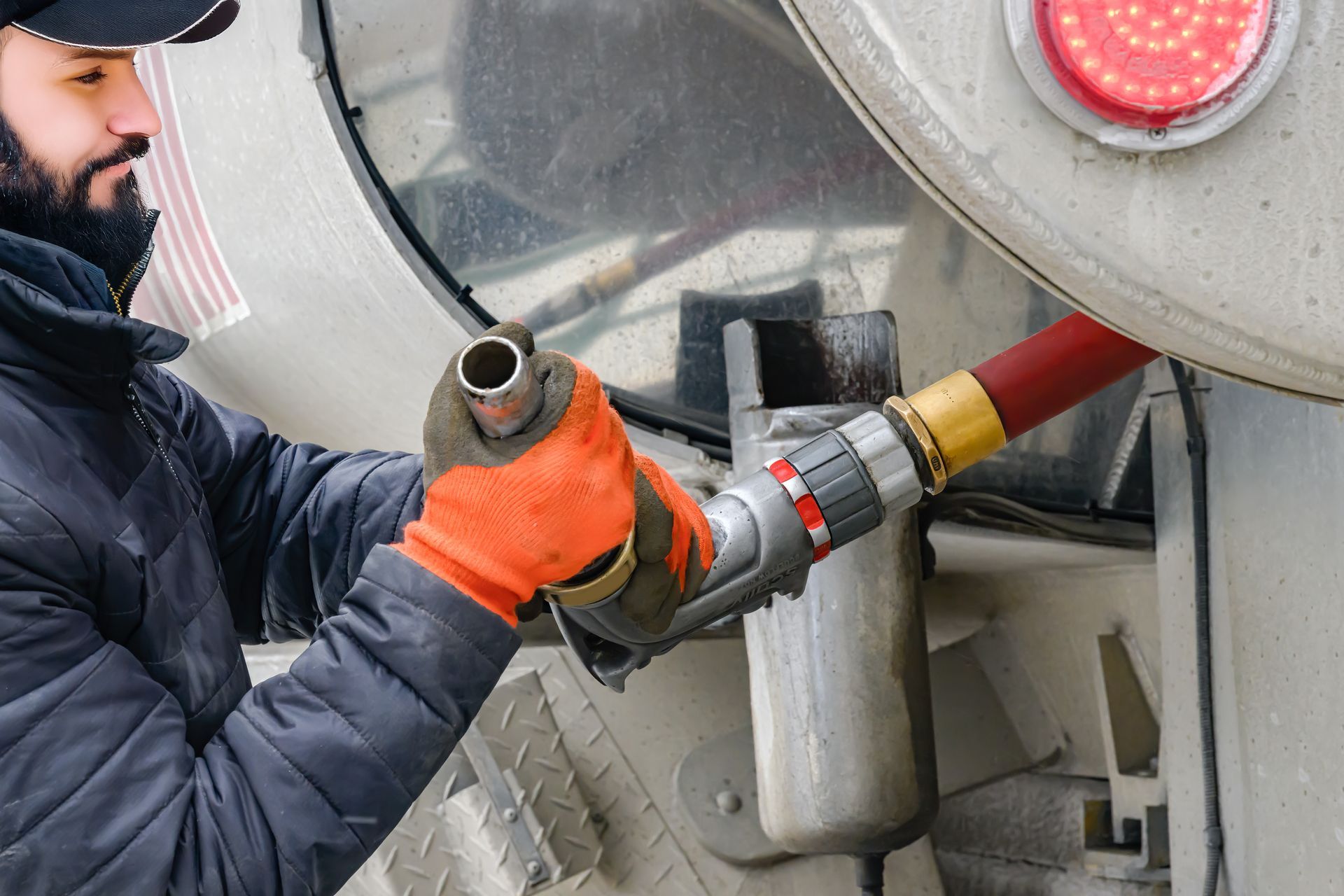 The technician connects the hose with care for safe heating oil delivery.