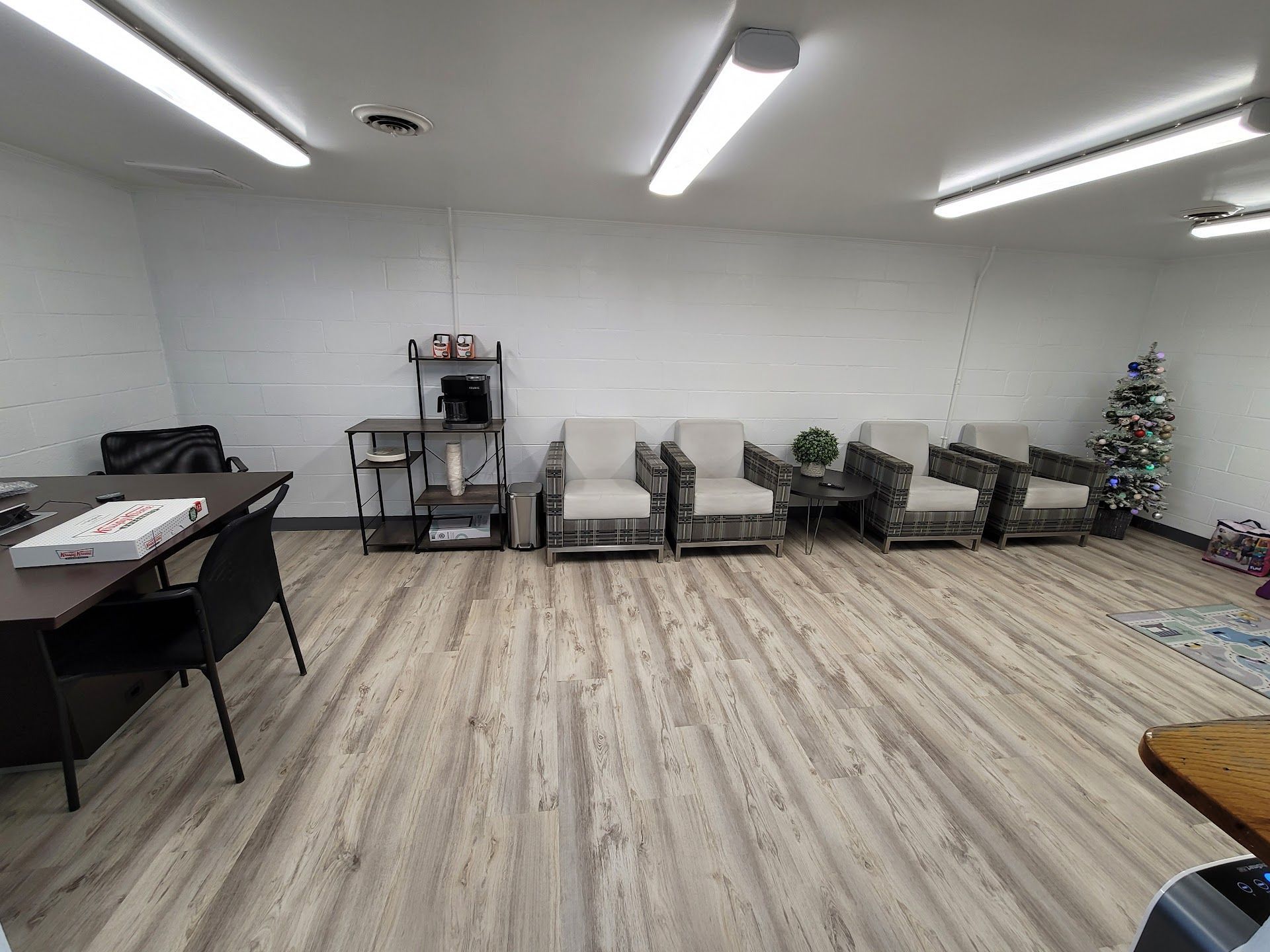 Office interior with seating area, coffee station, desk, and a small Christmas tree. | Zach's Auto Clinic