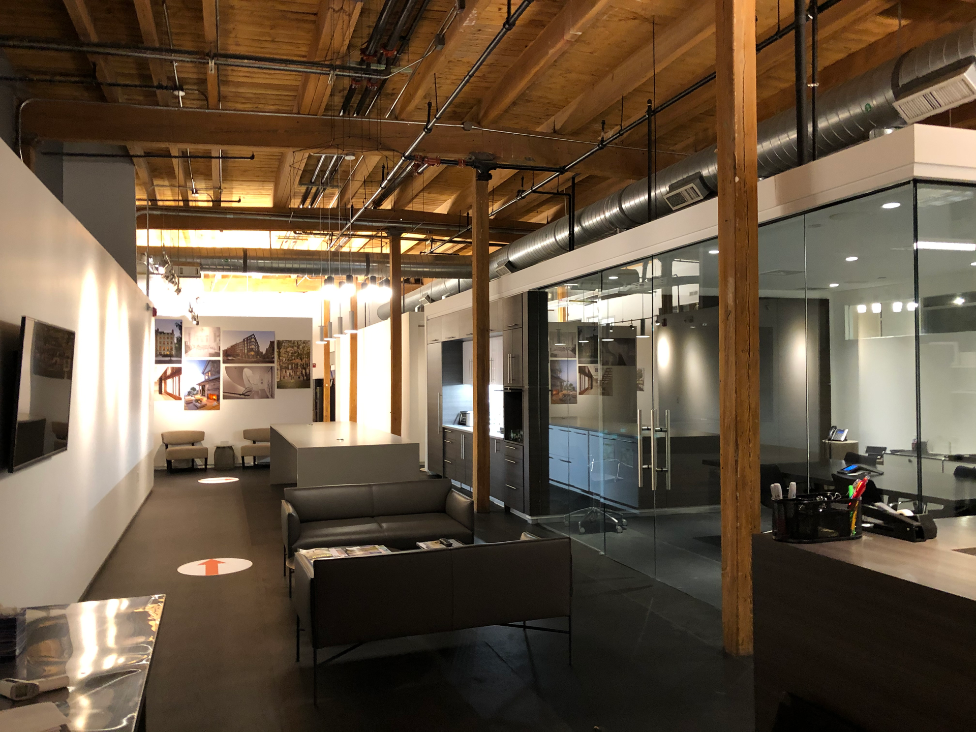 A large room with a lot of furniture and a wooden ceiling in a commercial office in Boston MA. This office reception is cleaned by ThinkFast Cleaning Services.