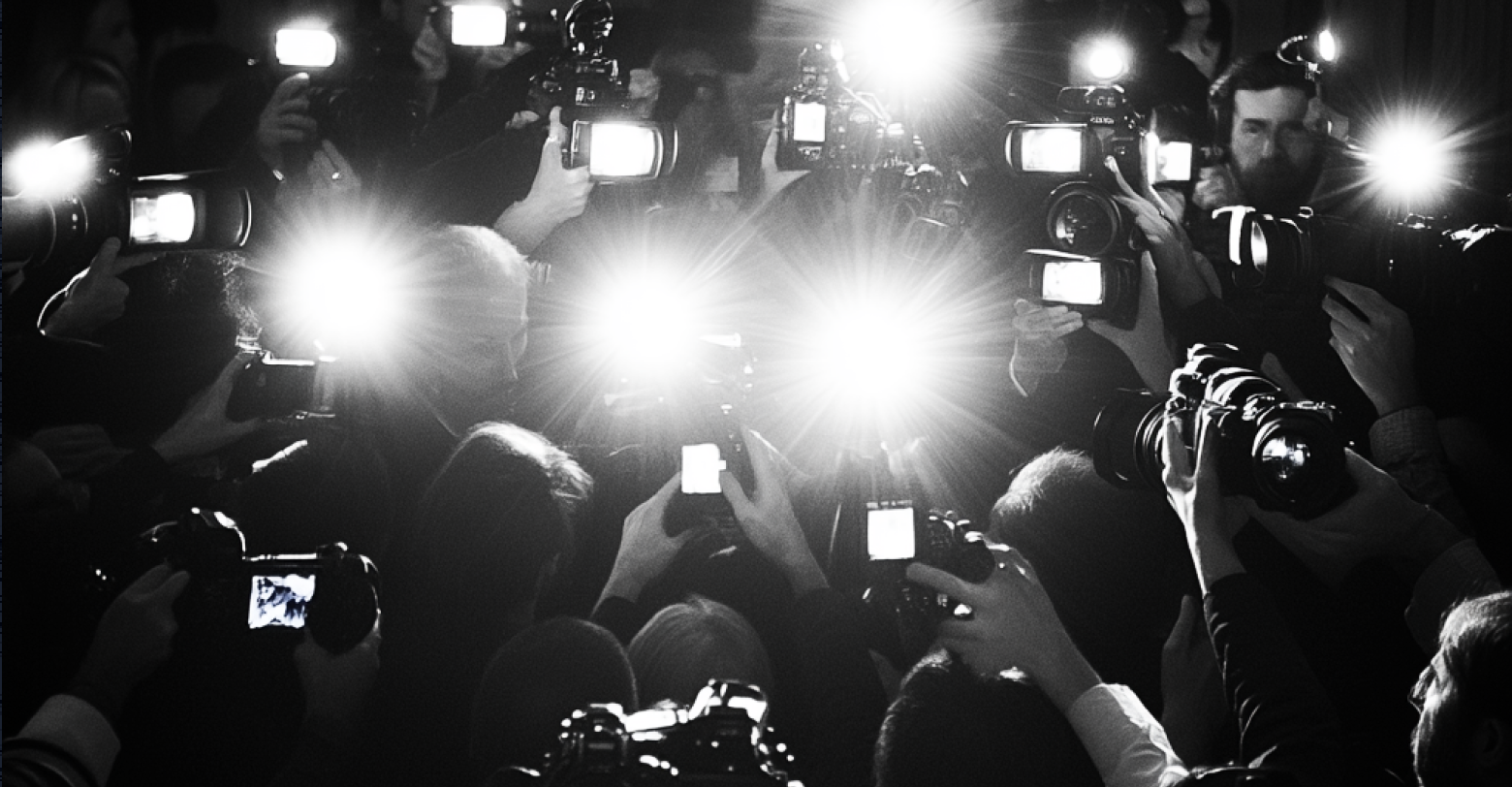 A crowd of journalists taking pictures with their cameras.