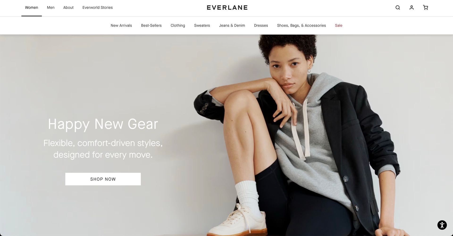 A screenshot of Everlane's homepage where a woman is sitting on the floor wearing a hoodie and a jacket.