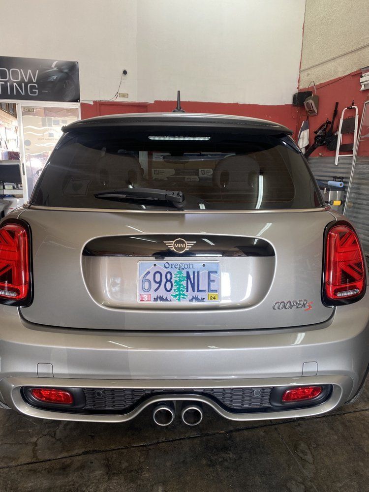 Silver Mini Cooper S car with Oregon license plate, in a shop, rear view.