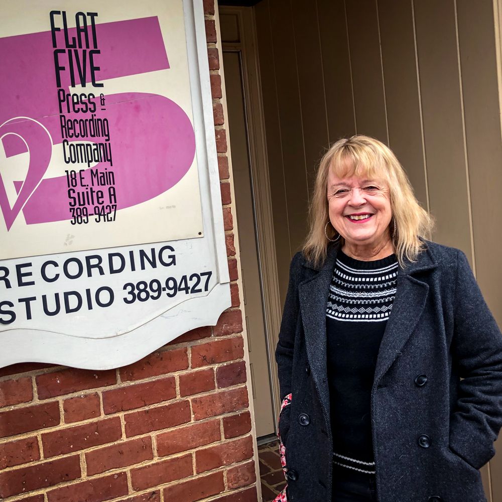 A woman is standing in front of a recording studio