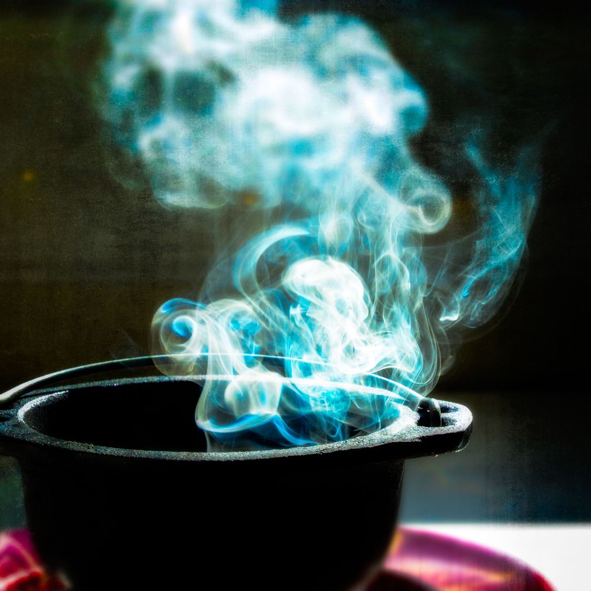 Smoke is coming out of a black pot on a table