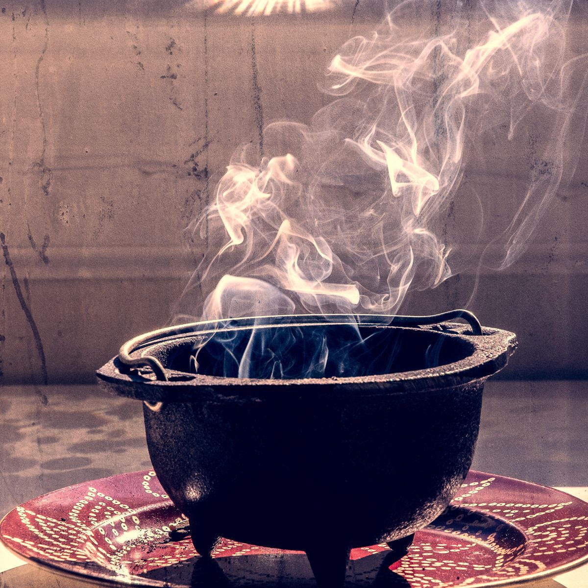 Smoke is coming out of a cauldron on a table