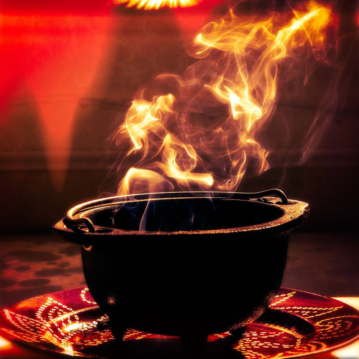A black pot with flames coming out of it