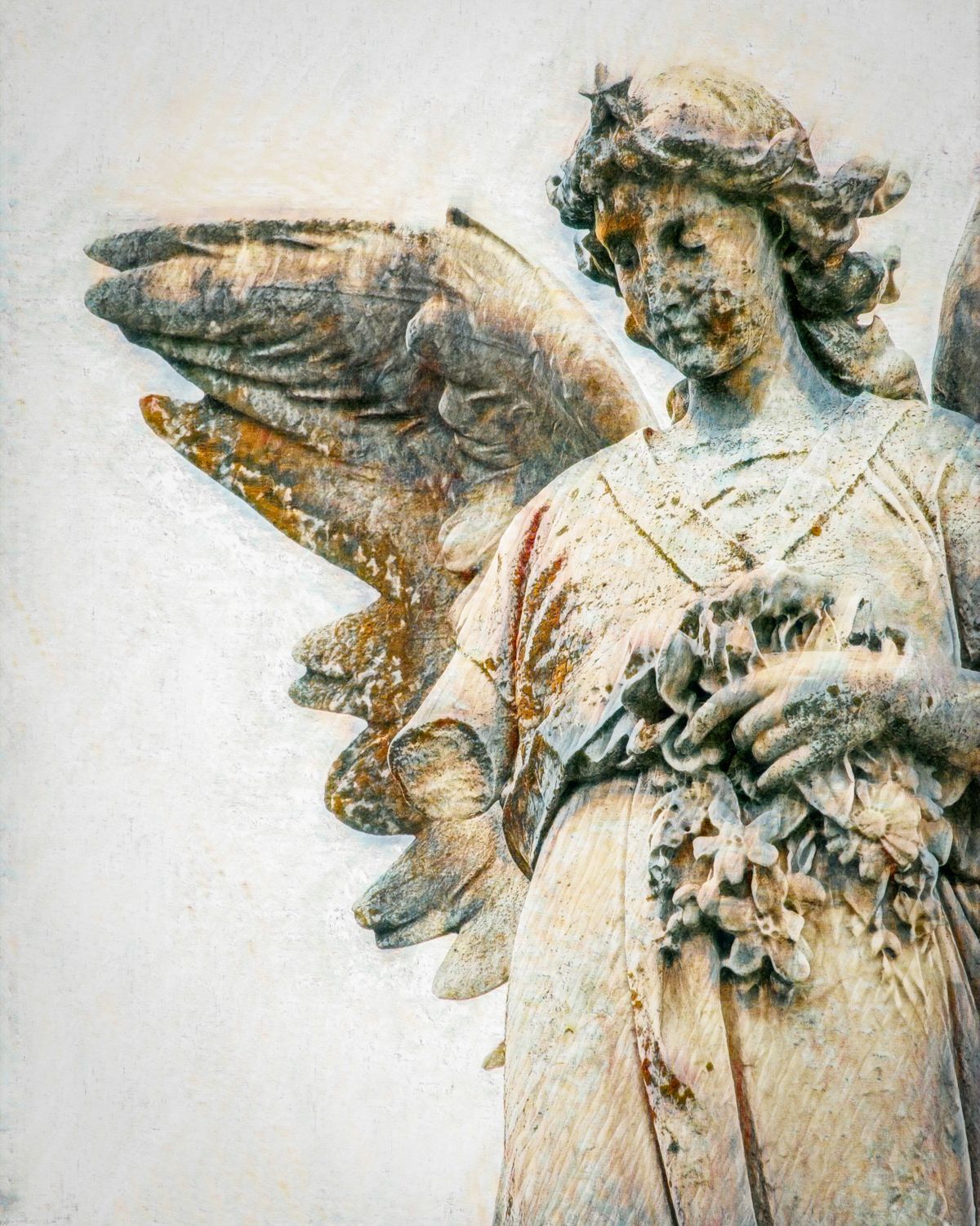 A statue of a woman with wings holding flowers