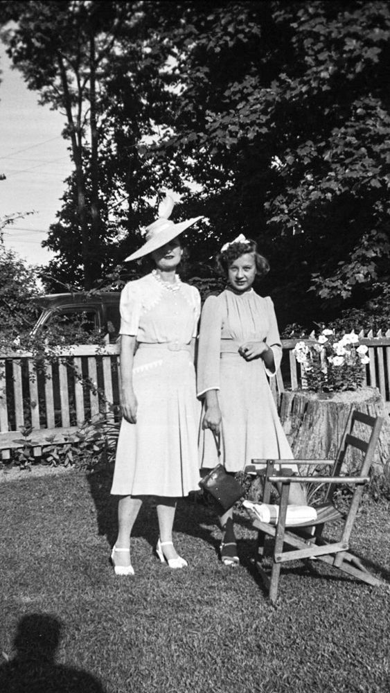 a black and white photo of two women standing next to each other