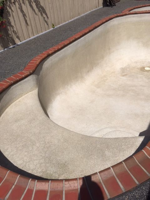 A large concrete pool with a brick border