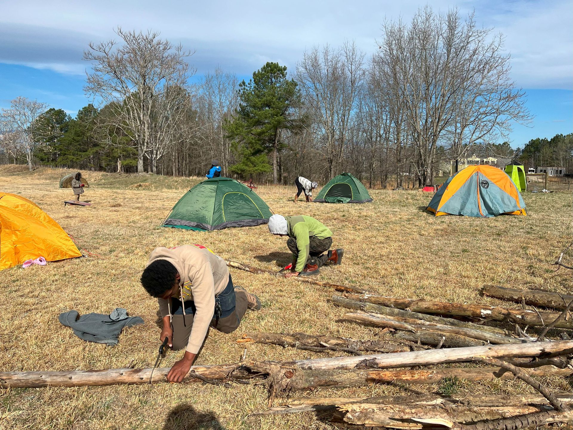A group of people are camping in a field with tents.