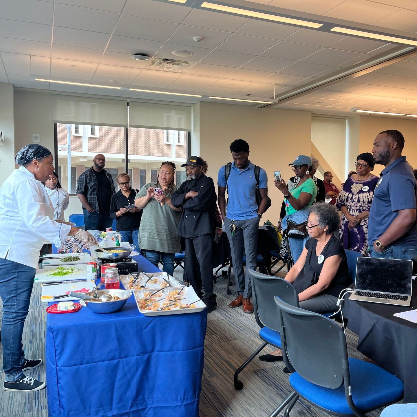 A group of people are gathered around a table with food on it