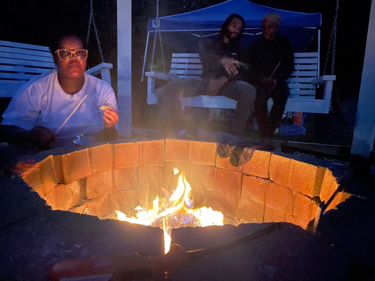 A group of people are sitting around a fire pit