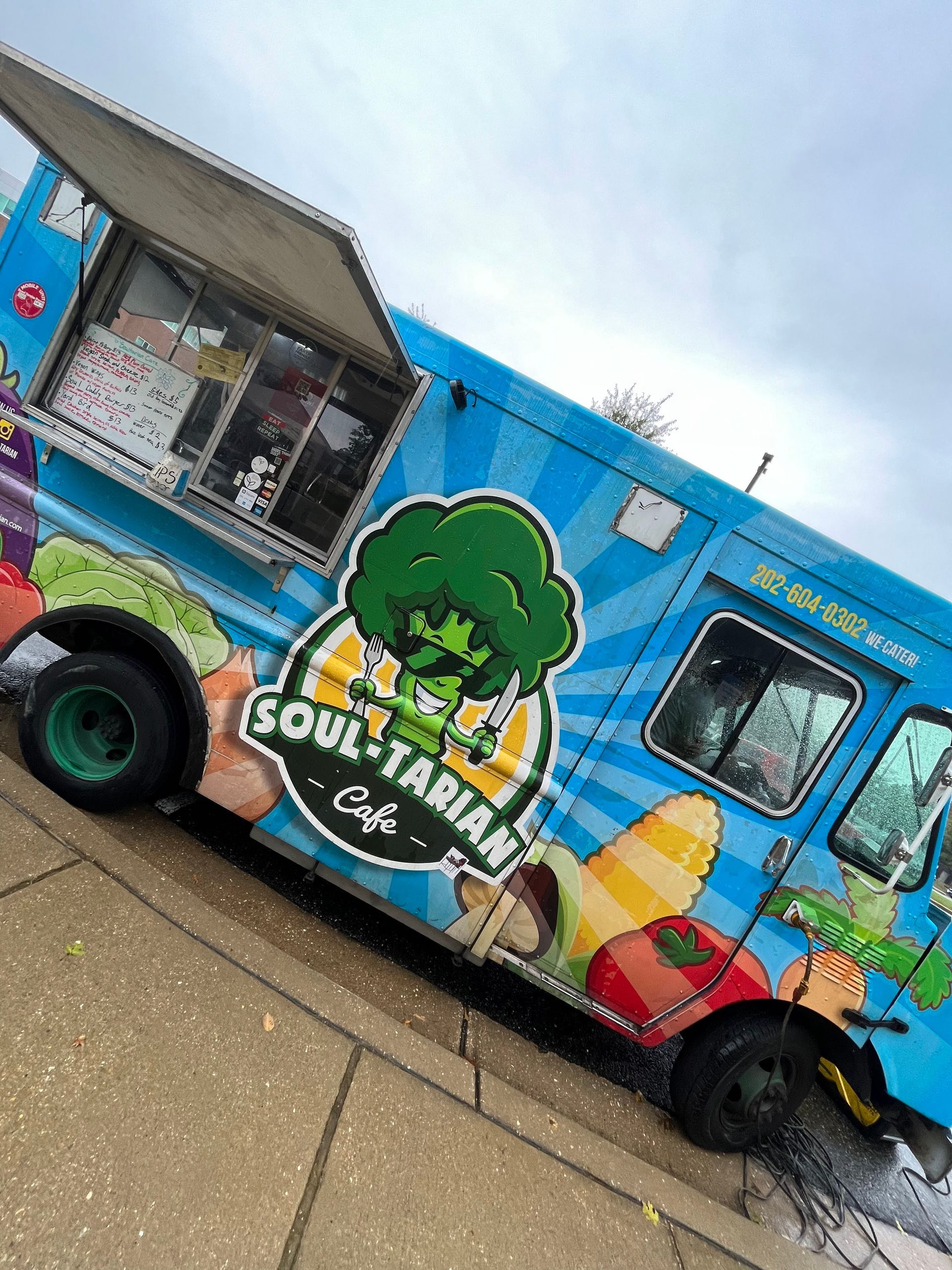 A blue food truck that says soulitarian cafe on it