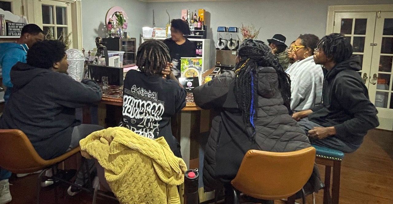 A group of people are sitting around a table in a room.