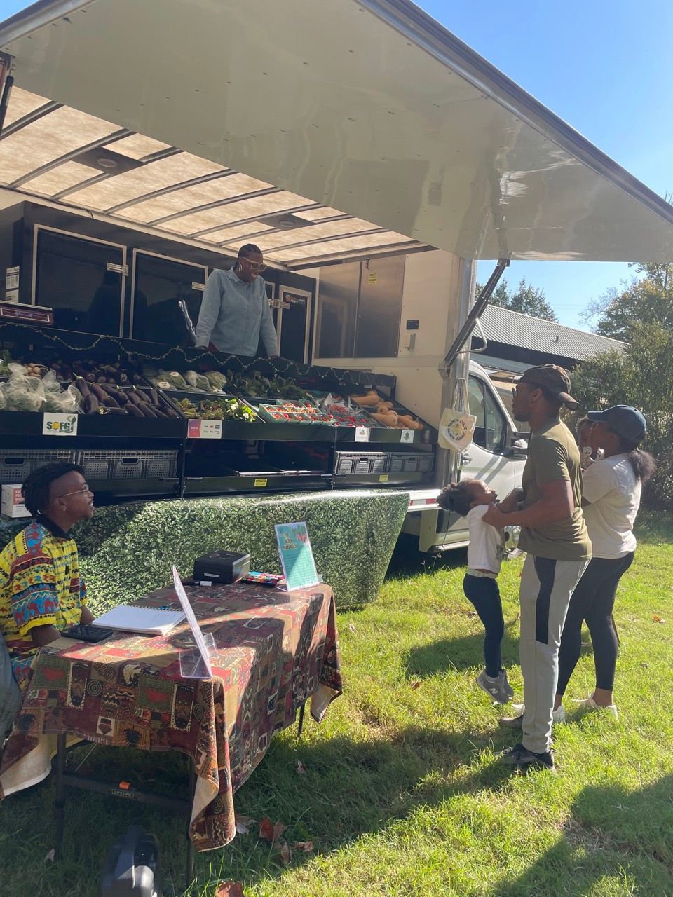 A group of people are standing in front of a food truck.