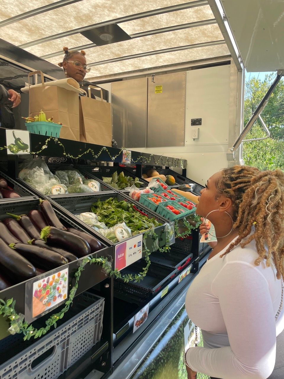 A man is sitting in a boat filled with vegetables.