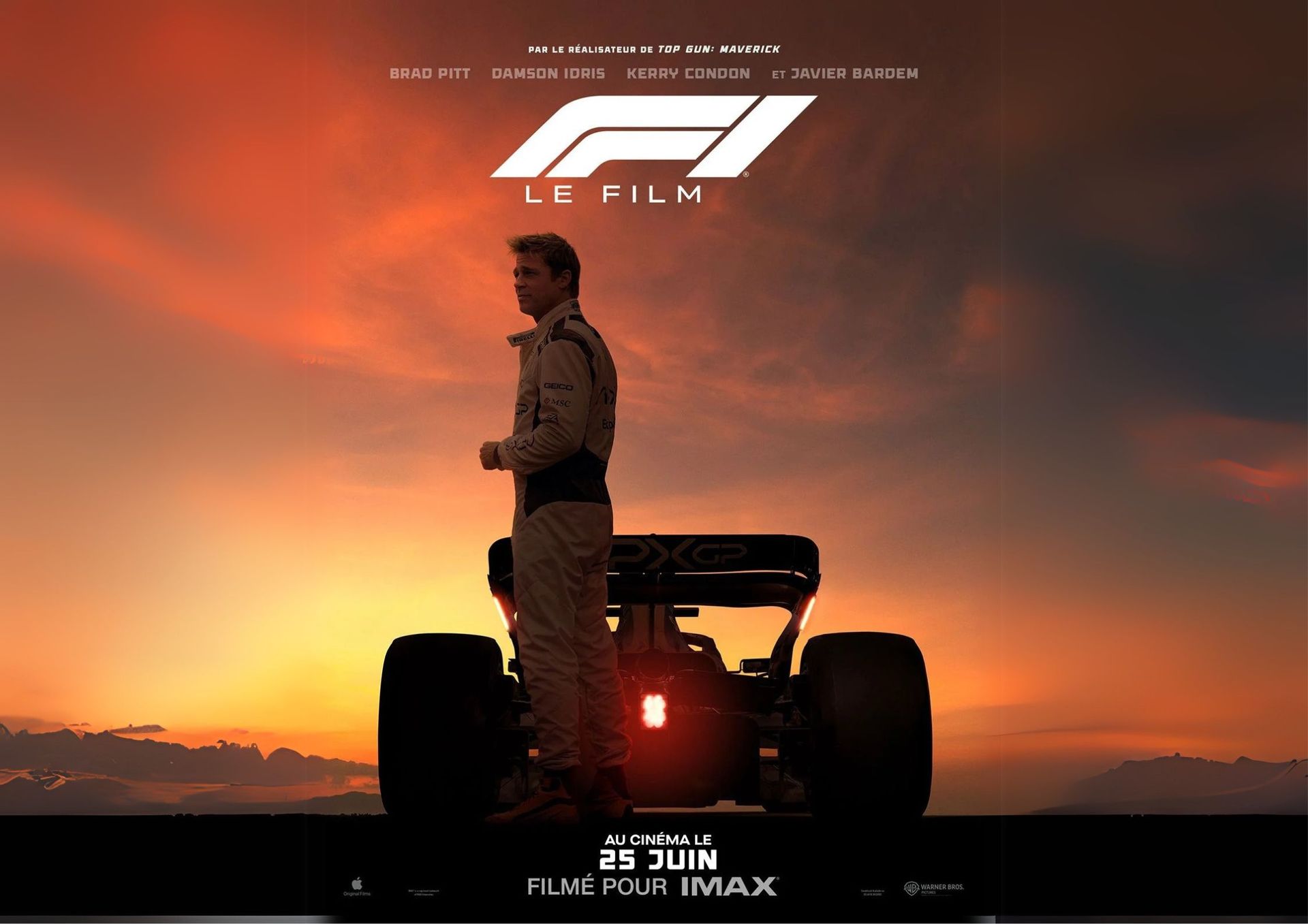 Un pilote debout derrière une formule 1, regardant l'horizon, avec un coucher de soleil en fond.