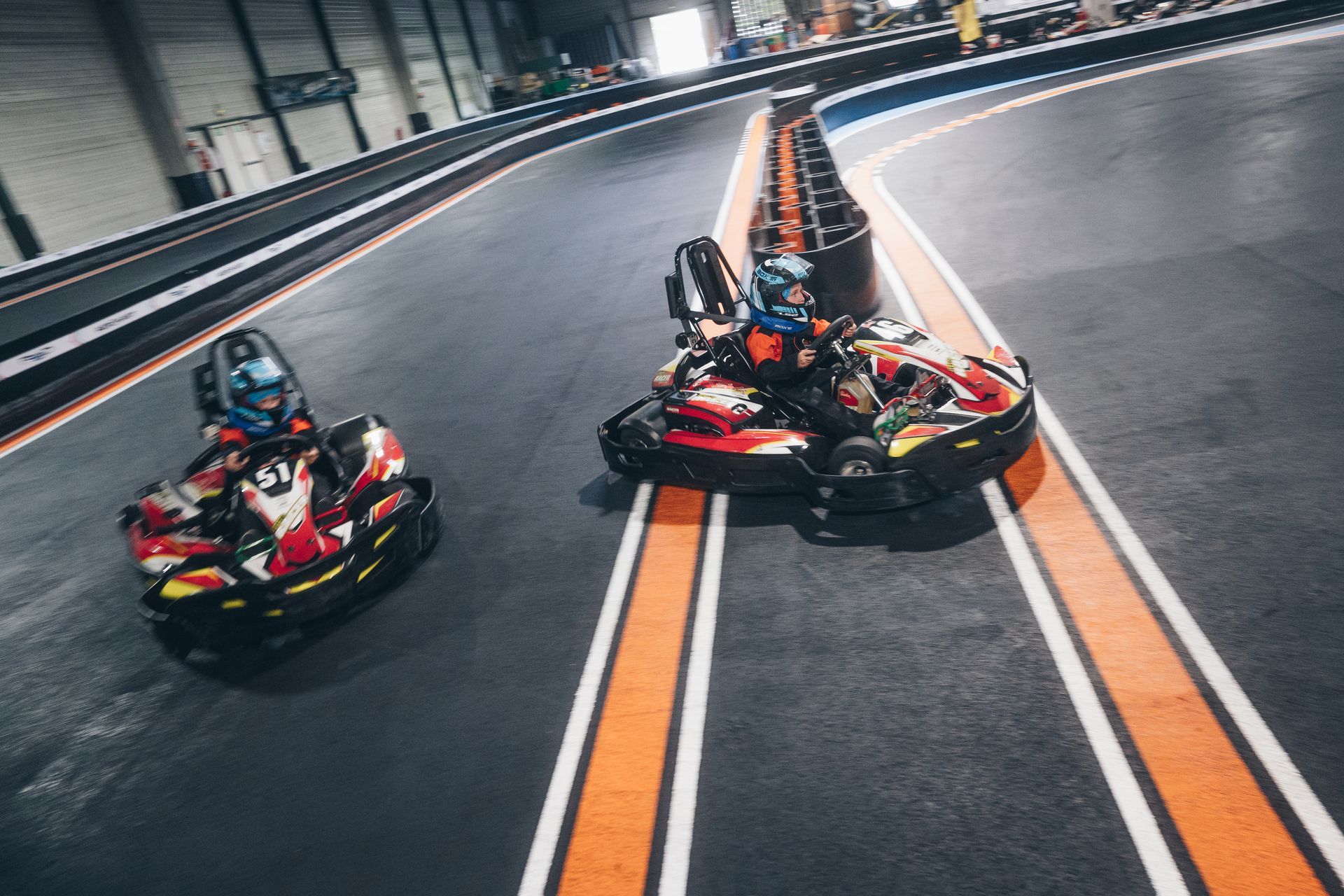 Un jeune garçon lève le pouce tout en étant assis dans un kart.