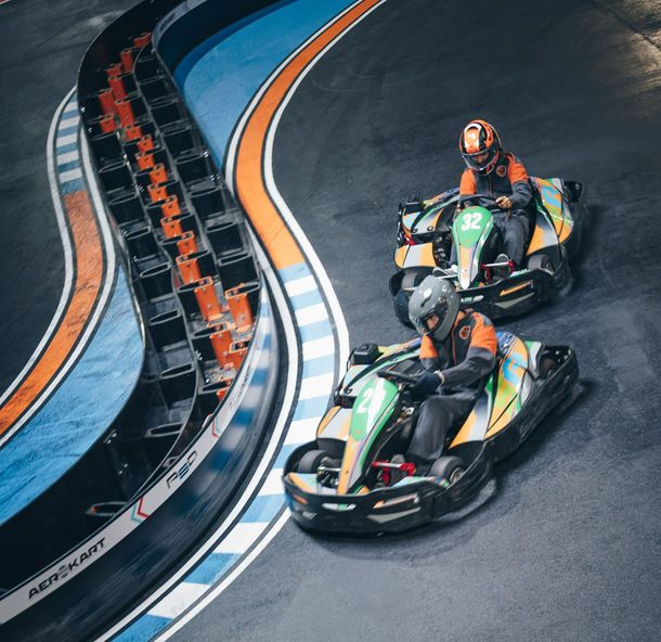 Un groupe de personnes font du kart sur une piste.