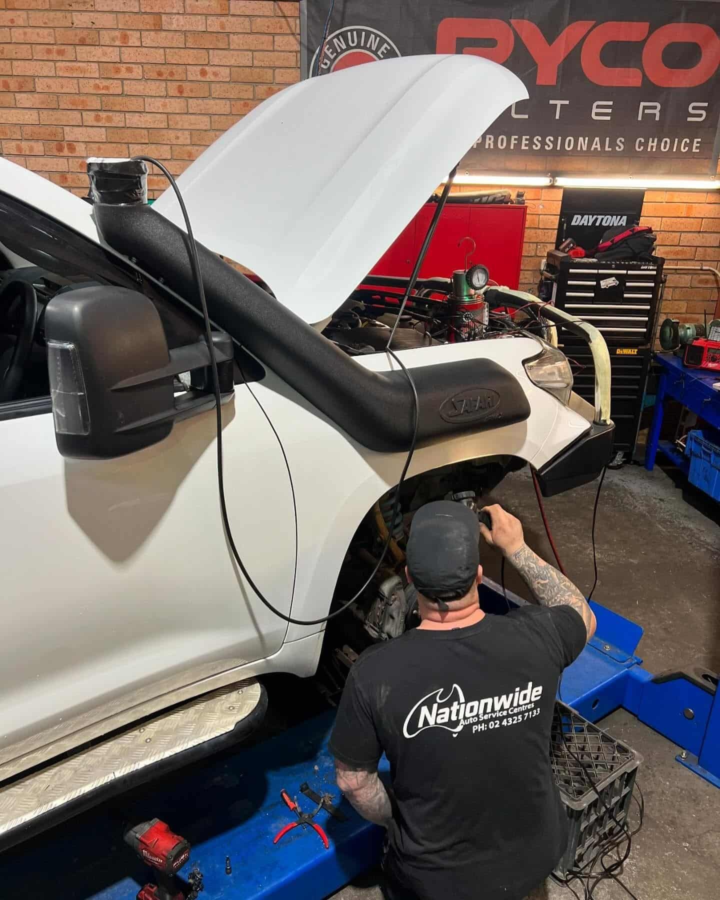 A Man is Working on a White Truck in a Garage — Nationwide Auto Service Centre in West Gosford, NSW