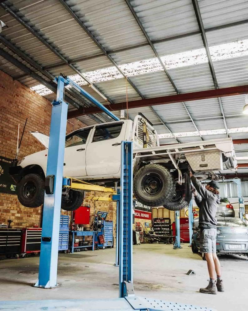A Man is Working on a Truck on a Lift in a Garage — Nationwide Auto Service Centre in West Gosford, NSW