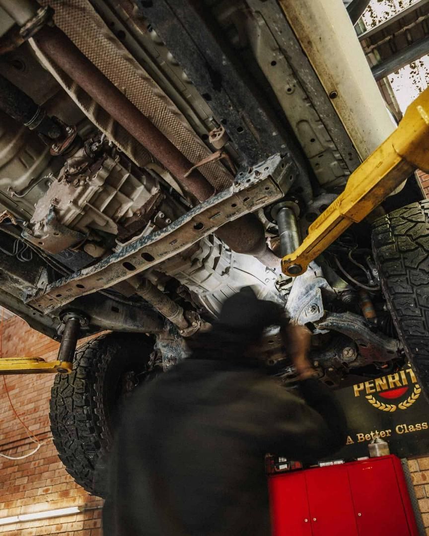 A Man is Working on the Underside of a Car in a Garage — Nationwide Auto Service Centre in West Gosford, NSW