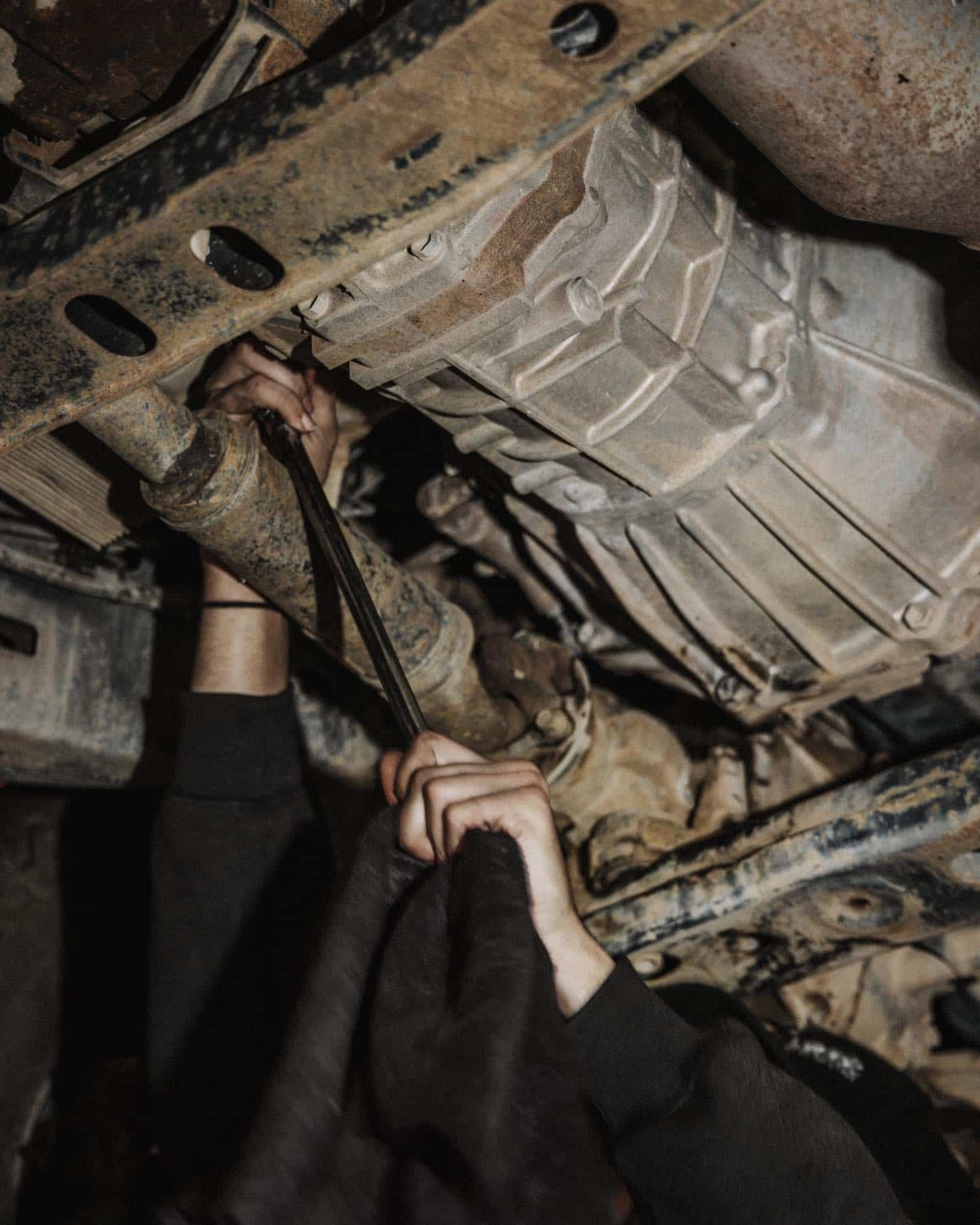 A Person is Working Under a Car With a Wrench — Nationwide Auto Service Centre in West Gosford, NSW