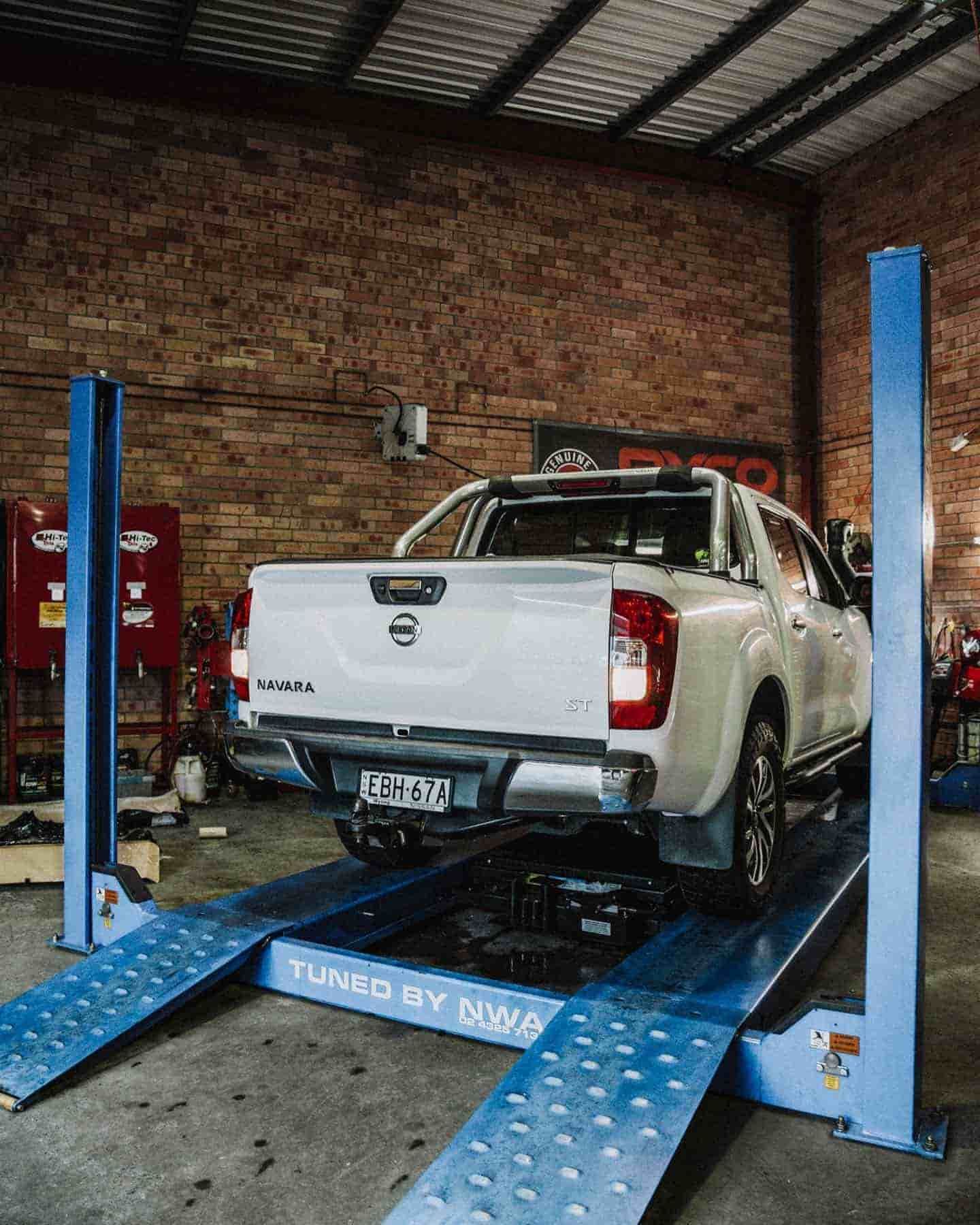 A White Truck is Sitting on a Lift in a Garage — Nationwide Auto Service Centre in West Gosford, NSW