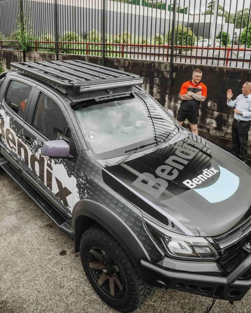 A Man is Standing Next to a Truck With a Roof Rack on Top of It — Nationwide Auto Service Centre in West Gosford, NSW