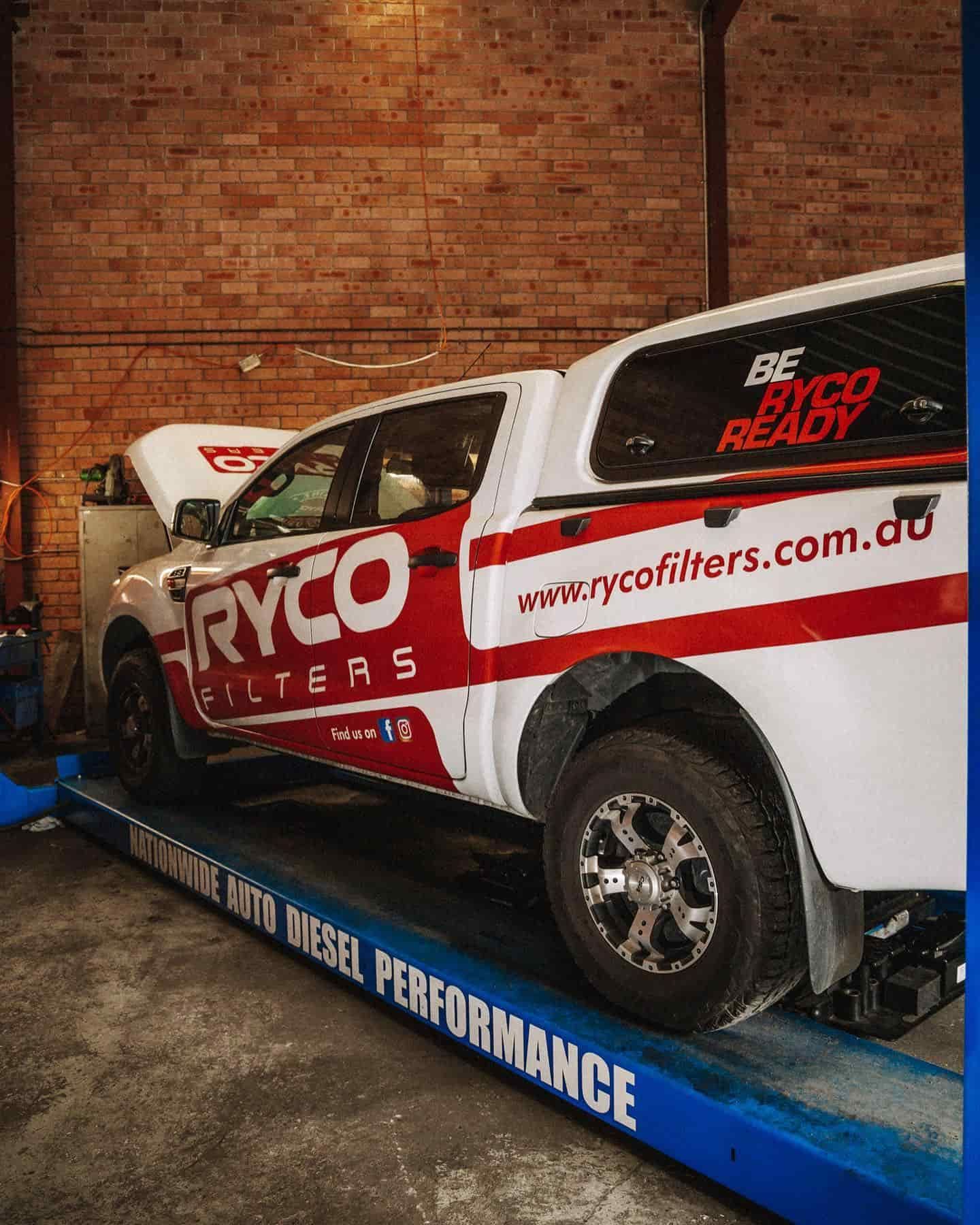 A Ryco Truck is Sitting on a Lift in a Garage — Nationwide Auto Service Centre in West Gosford, NSW