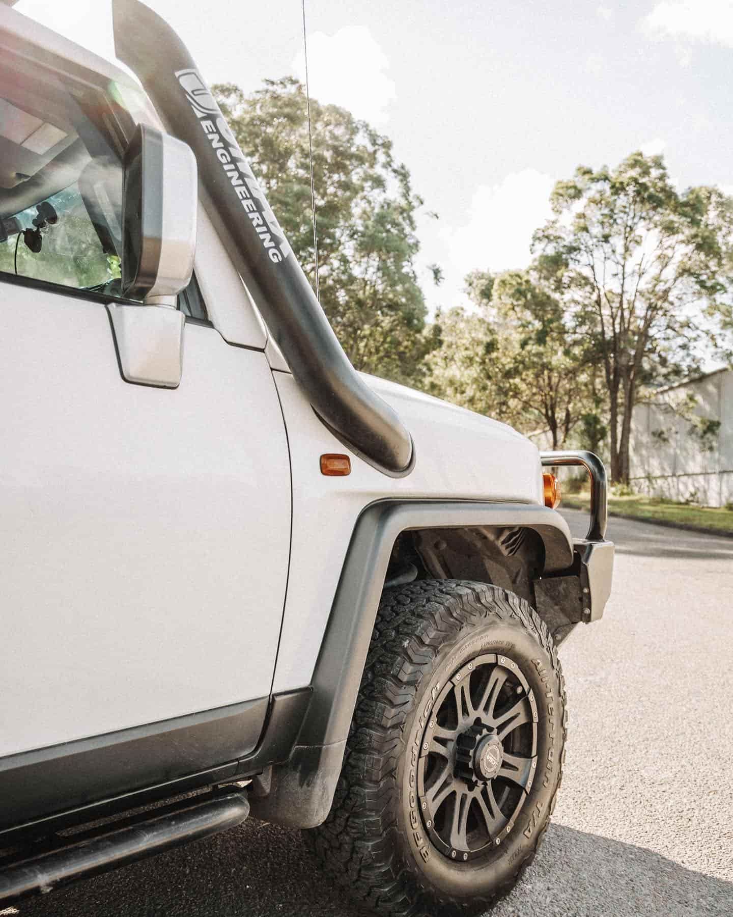 A White Jeep With a Black Snorkel is Parked on the Side of the Road — Nationwide Auto Service Centre in West Gosford, NSW