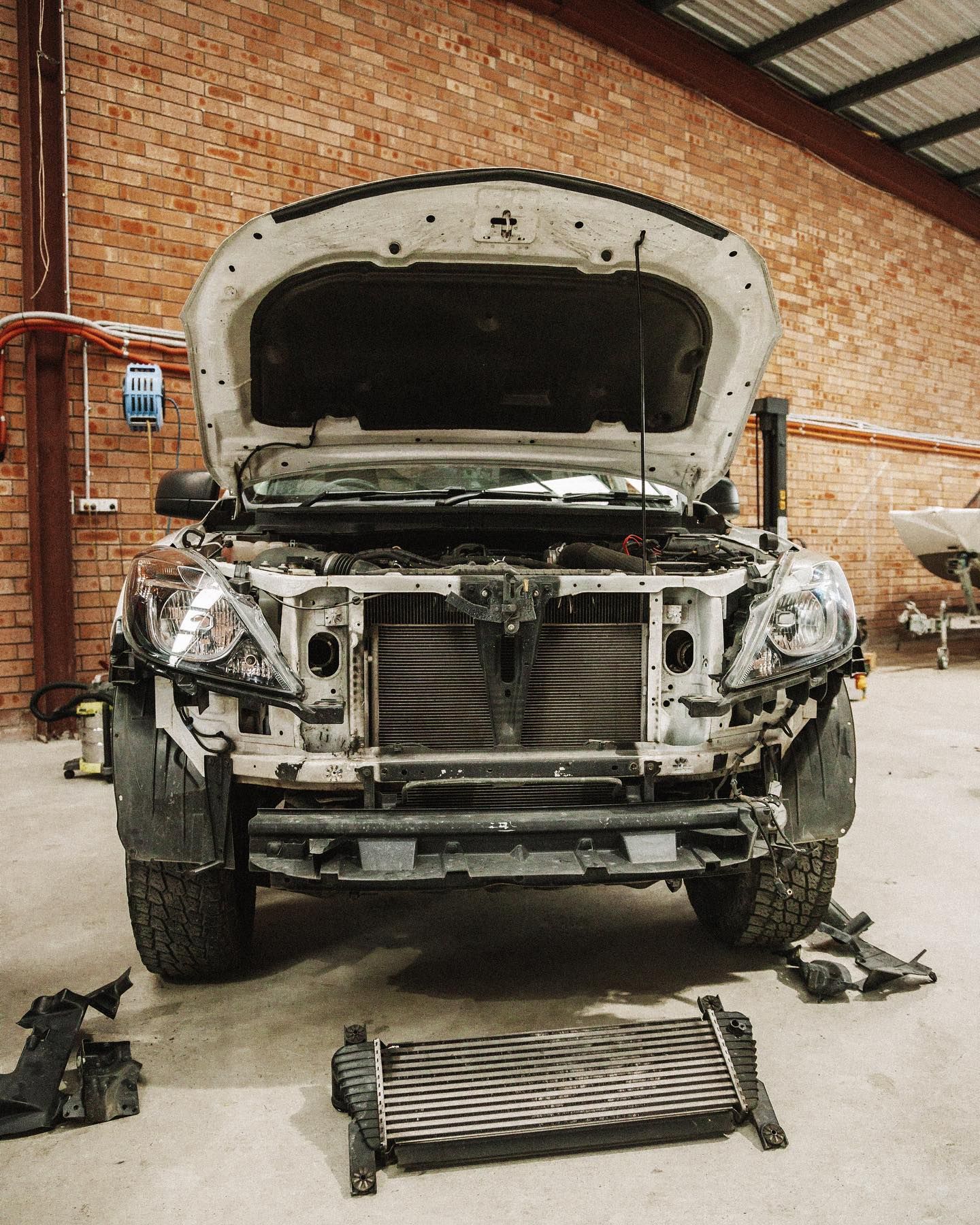 A White Truck is Being Repaired in a Garage With the Hood Open — Nationwide Auto Service Centre in West Gosford, NSW