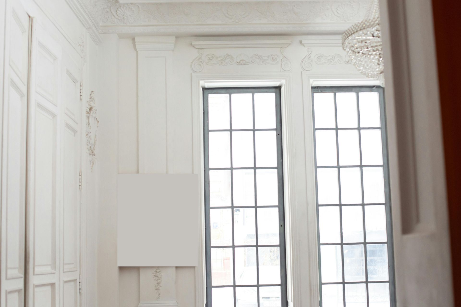 A room with a lot of windows and a chandelier hanging from the ceiling.