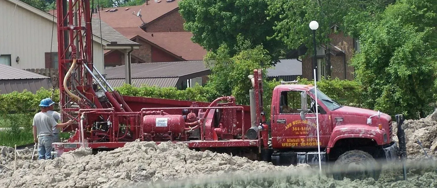 A pressure gauge is sitting on top of a pipe in a factory.