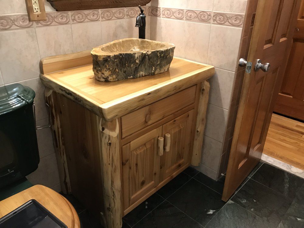 Rustic wooden bathroom vanity with a live-edge countertop and log-shaped sink.