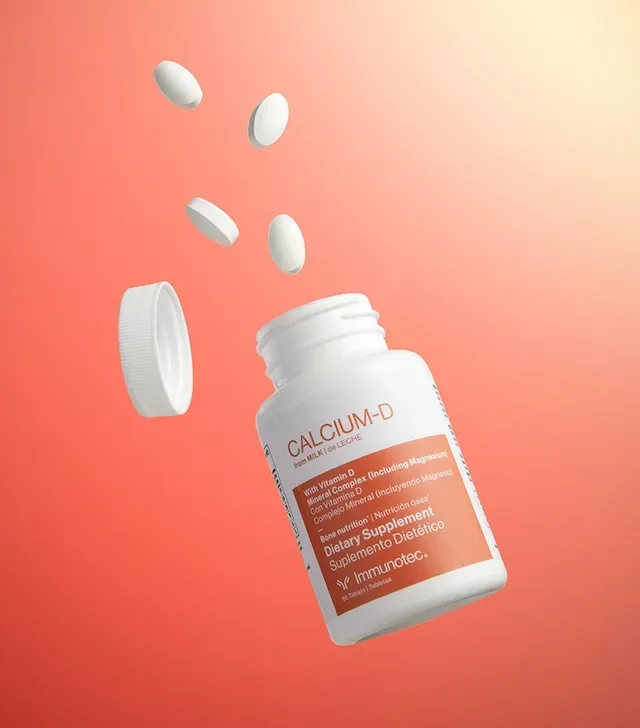 Suplemento de calcio-D de color blanco derramándose desde una botella blanca.