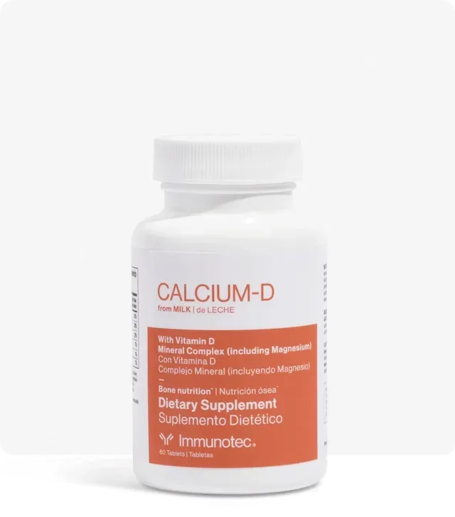 Suplemento de calcio-D de color blanco derramándose desde una botella blanca.