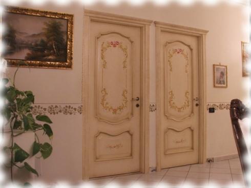 Un corridoio con due porte e un quadro sul muro.