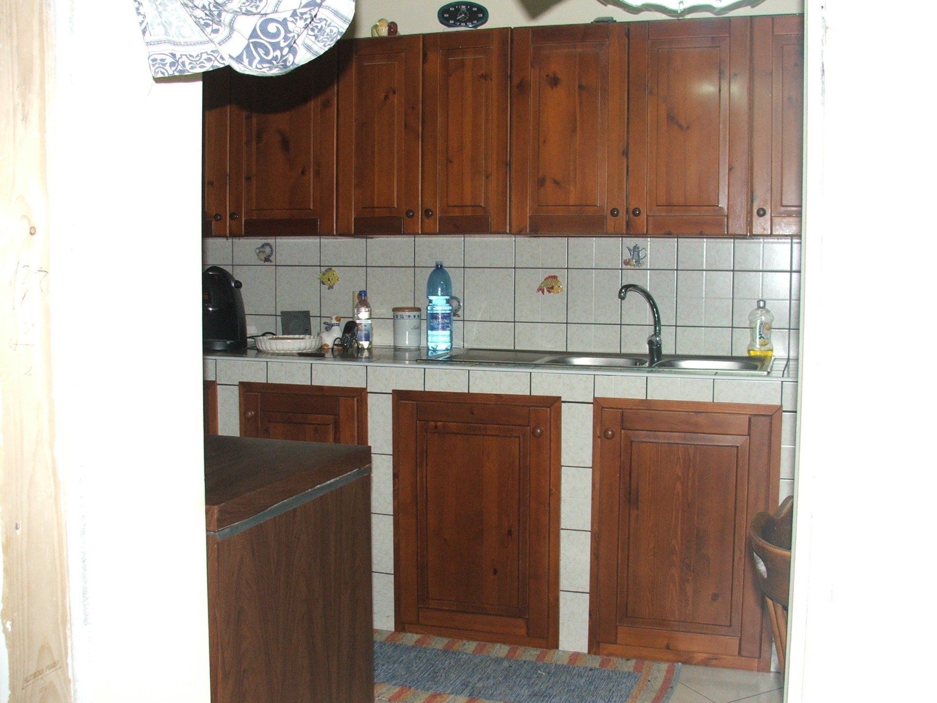 Una cucina con mobili in legno e un lavandino